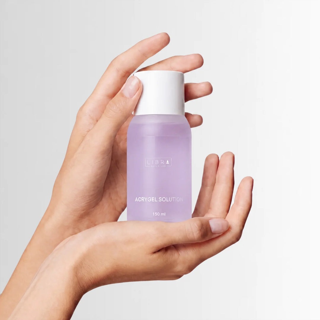 Flacon d'Acrygel Solution 150 ml Libra Nails Lab tenu en main, liquide de modelage pour acrygel HEMA Free